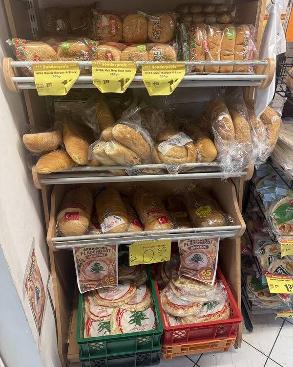 Brotregal mit Weißbrot, Fladenbrot und Brötchen